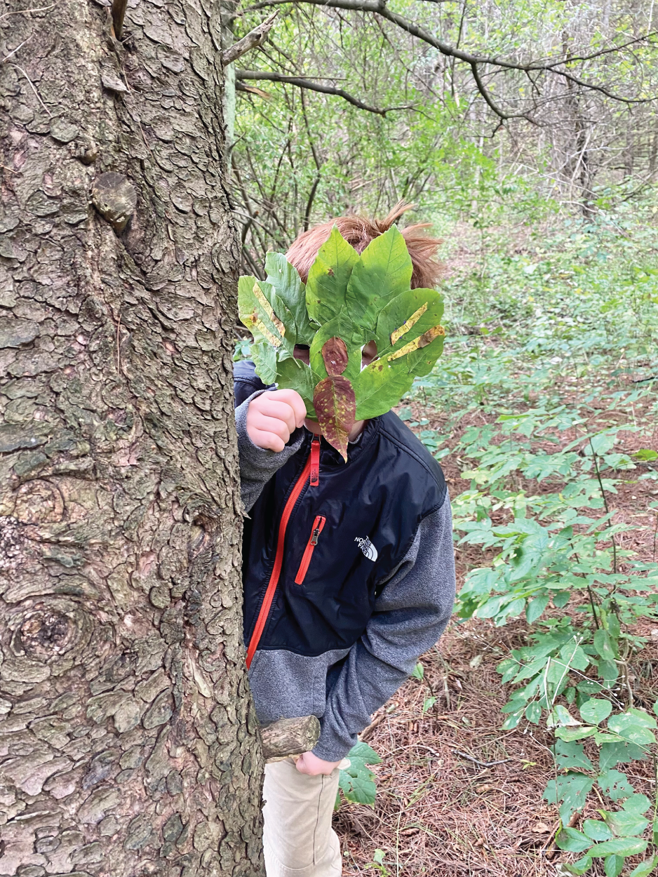 Photo depicts acting out a story wearing a mask made from natural materials.