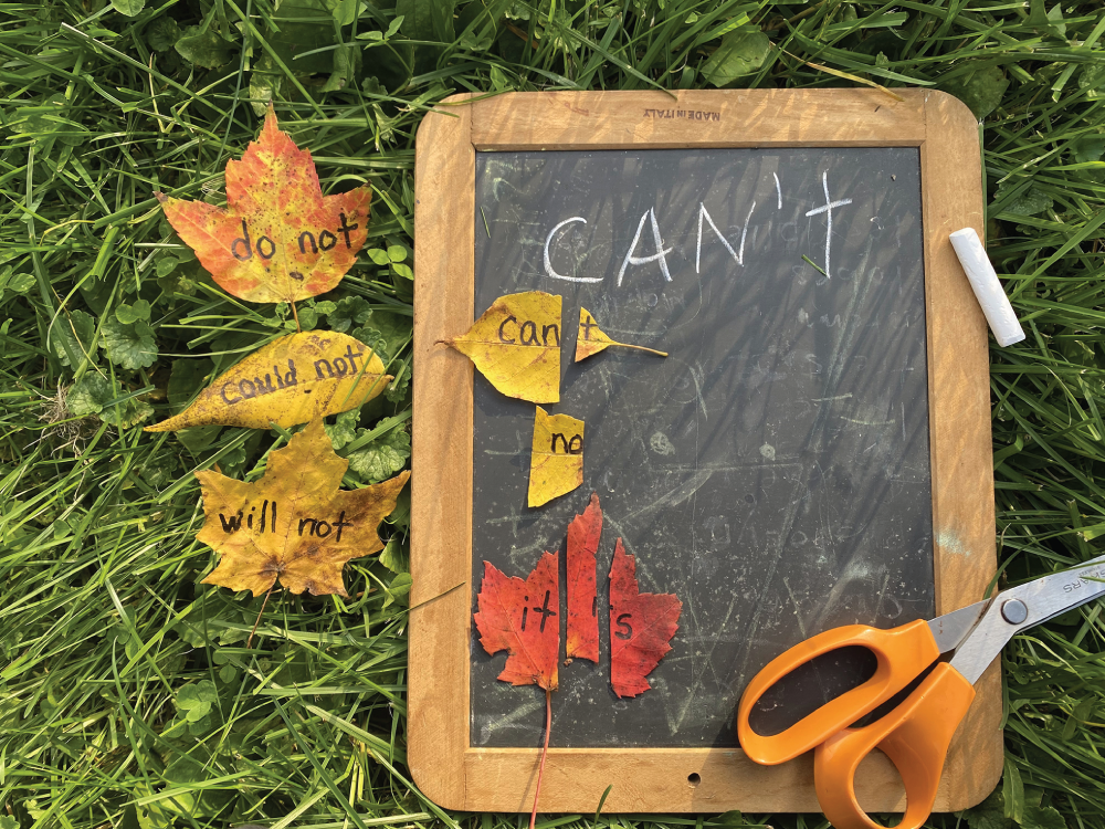 Photo depicts cutting words written on leaves to create contractions.