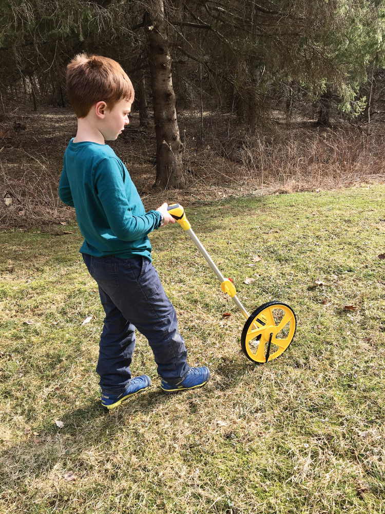 Photo depicts using a trundle wheel to measure distances