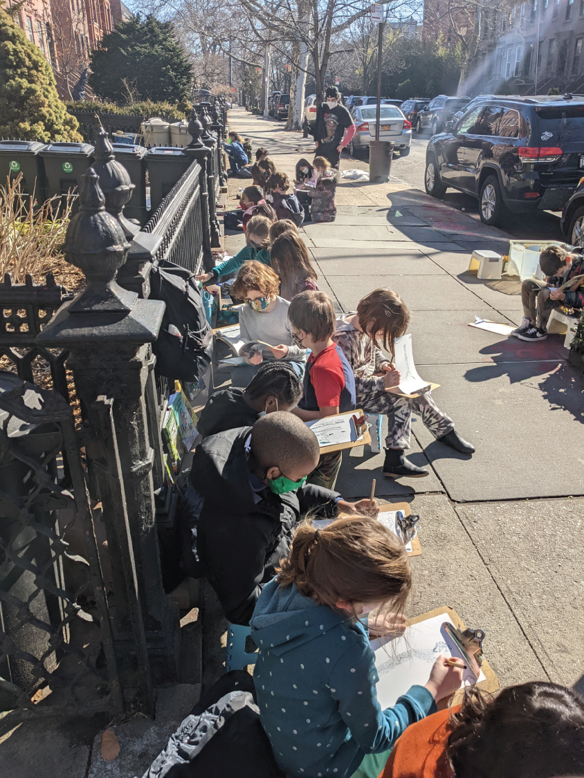 Photo depicts students using the street as inspiration for writing stories.