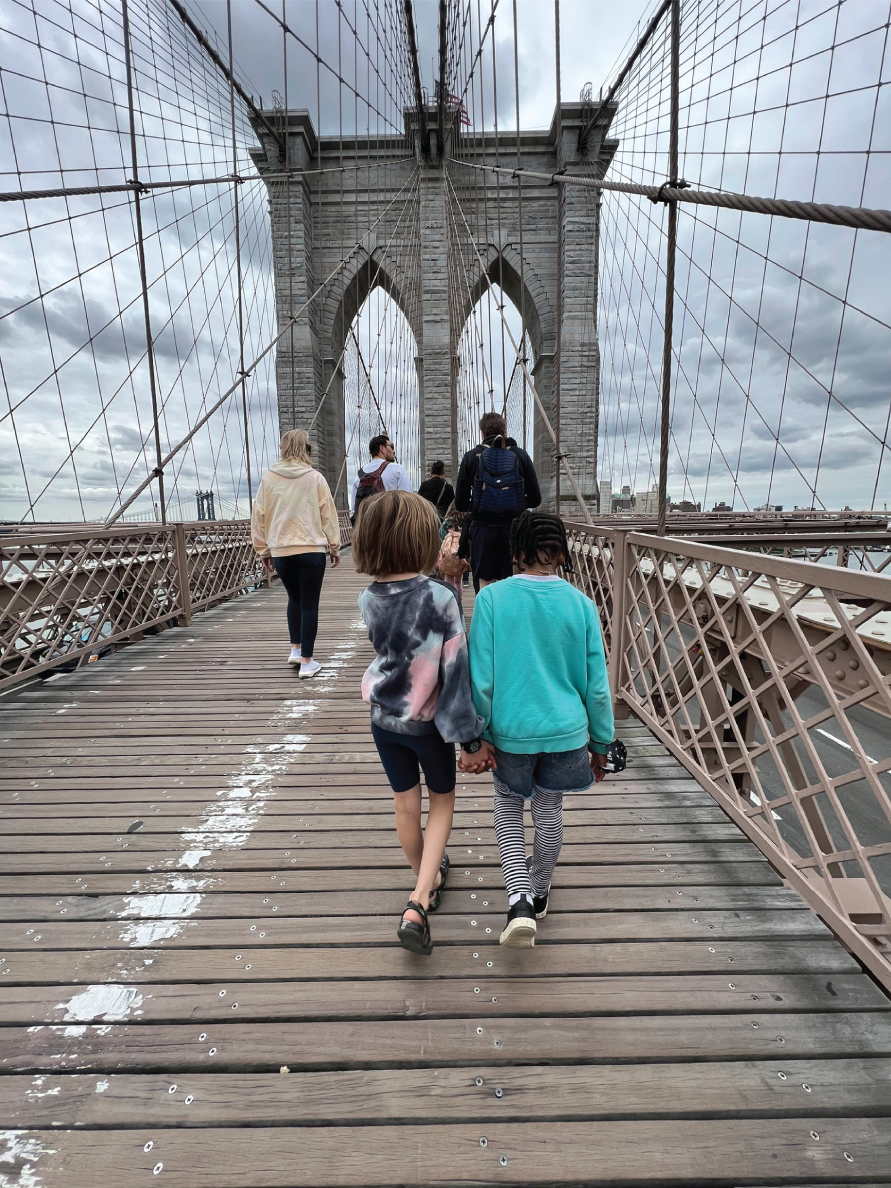 Photo depicts students from The Brooklyn New School visit the Brooklyn Bridge for their study of bridges.