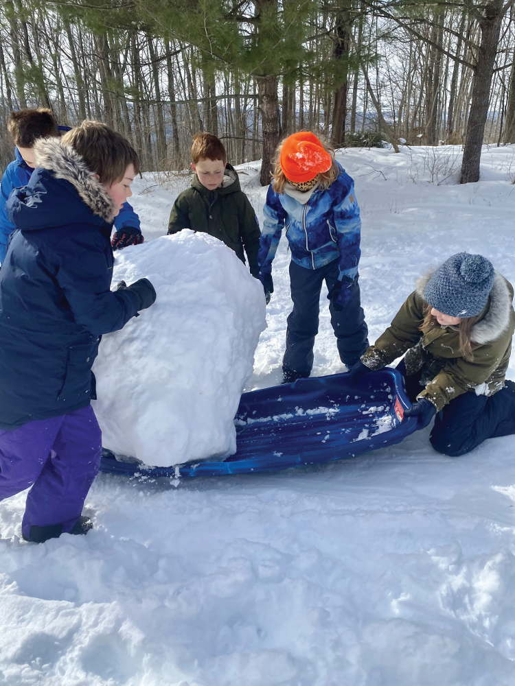 Photo depicts sledding experiment using a giant snowball as the load.