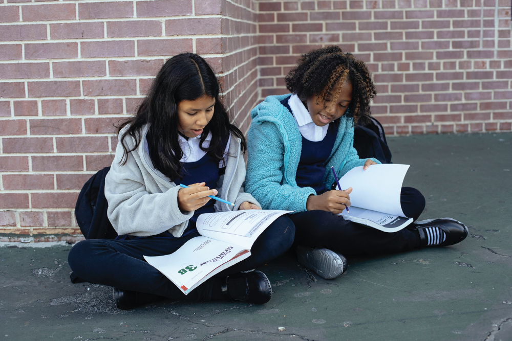 Photo depicts students working in the schoolyard.